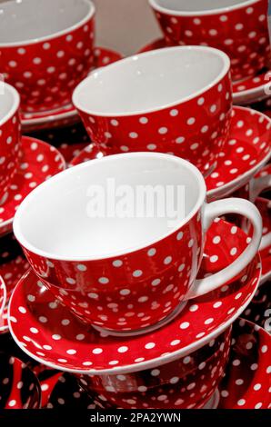 Stack of red with white dots coffee cups for sale in a houseware store. Display - Retail industry Stock Photo