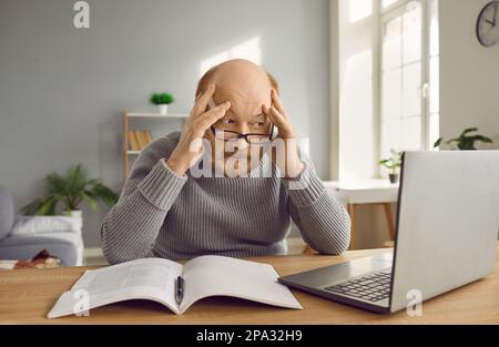 Confused senior man working with laptop having panic look and feeling stressed because of deadline. Stock Photo