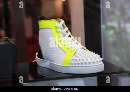 Honolulu, Hawaii - June 19, 2020: Fashionable white sneakers with neon yellow trim by luxury French fashion designer Christian Louboutin Stock Photo