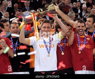 AS Roma's captain Francesco Totti, center with white jersey, sorrounded by  teammetes, holds the trophy with Italian President Giorgio Napolitano,  second from right, and Italian soccer league president Antonio Matarrese,  right, after