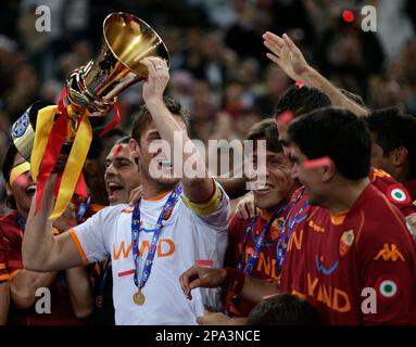 AS Roma's captain Francesco Totti, center with white jersey, sorrounded by  teammetes, holds the trophy with Italian President Giorgio Napolitano,  second from right, and Italian soccer league president Antonio Matarrese,  right, after