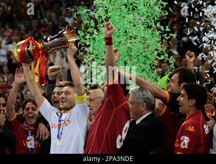 AS Roma's captain Francesco Totti, center with white jersey, sorrounded by  teammetes, holds the trophy with Italian President Giorgio Napolitano,  second from right, and Italian soccer league president Antonio Matarrese,  right, after