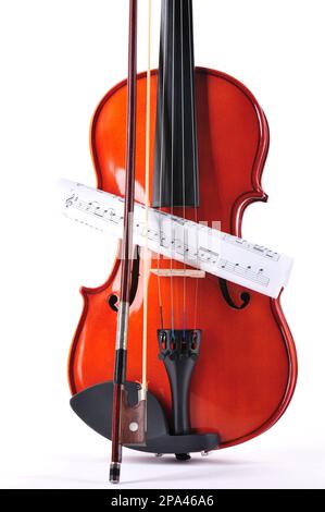 violin made of rosewood against a white background with music sheet Stock Photo