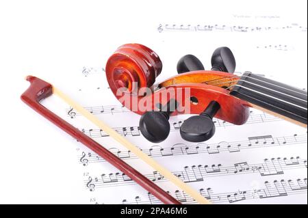 violin made of rosewood against a white background with music sheet Stock Photo