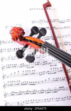 violin made of rosewood against a white background with music sheet Stock Photo