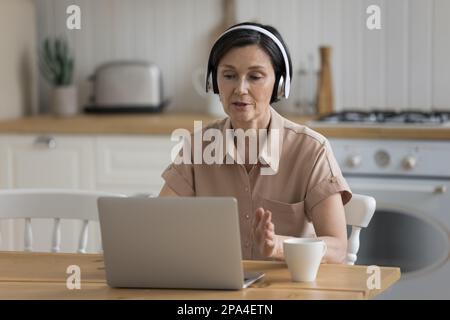 Focused busy senior coach, influencer woman giving lecture Stock Photo