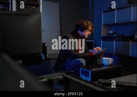 IT technician using digital tablet while working in data center Stock Photo