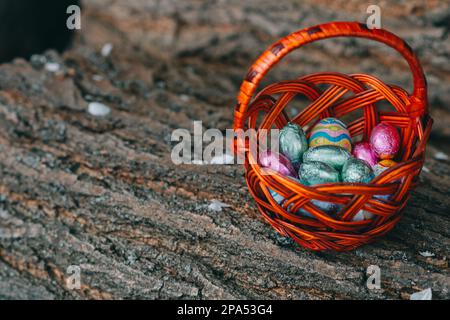 Pastel color Easter chocolate eggs in a basket, vintage green background, shallow depth of field nice Stock Photo