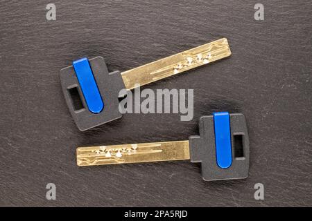 Two metal keys from a door lock on slate stone, macro, top view. Stock Photo