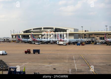 Dallas Fort Worth International Airport in Texas, USA. American Airlines Airbus A321 airliners outside terminal with Skylink train. Ground handling Stock Photo