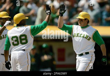 Oakland Athletics' Jack Cust, right, gets a handshake from third base coach  Tony DeFrancesco after Cust hit a two-run home run off Texas Rangers' Eric  Hurley in the first inning of a