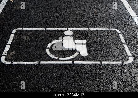 Handicap symbol on road. Road marking on the asphalt with parking spaces for the disabled. wheelchair symbol of disabled parking lot for handicapped p