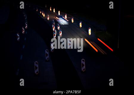 Cars on a road with roadworks. Works on the road. Night traffic. Stock Photo