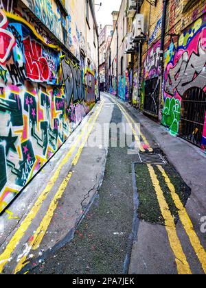 Colourful graffiti covered walls of a narrow alley off Corn Street in the old city of Bristol UK Stock Photo