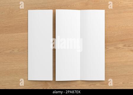 Half-folded flyer A4 vertical booklet mock up on wooden background. View directly above Stock Photo