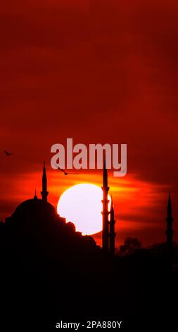 Suleymaniye Mosque and sun at sunset. Islamic or ramadan vertical photo. Ramadan or kadir gecesi or laylat al-qadr concept vertical story photo. Stock Photo