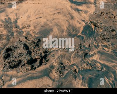 Background with abstract sand shapes created by the waves after washing the beach in Las Canteras Stock Photo