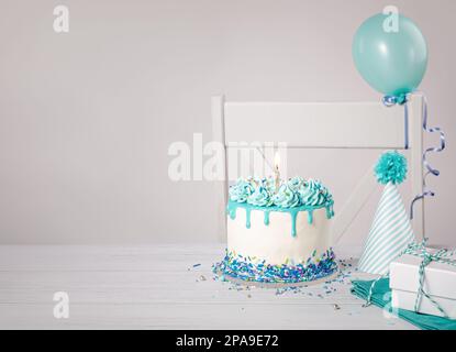 Blue and white birthday party with drip cake, sprinkles, candle, and ...