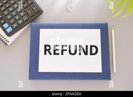 Writing note showing REFUND on light background. Business concept. Flat lay, Top View Pencil, Notebook and calculator Stock Photo