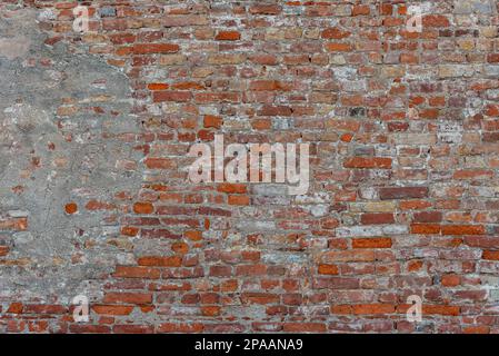 Wall texture with ancient plaster and peeling background with exposed red old brick Stock Photo