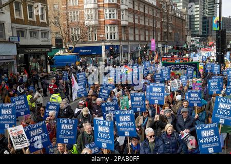 London, UK. 11th Mar, 2023. NHS workers including doctors and nurses and their supporter hold placards during the demonstration. SOS NHS campaign group and other trade unions organised a march from University College London Hospital to Downing Street to demand emergency funding for the National Health Service (NHS) from the UK Government to support services and staff and not to privatise the healthcare sector ahead of the Chancellor's spring budget on 15th March 2023. Credit: SOPA Images Limited/Alamy Live News Stock Photo