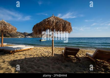 View of luxury sun beds and sun umbrellas at the famous Mylopotas beach in Ios Greece Stock Photo
