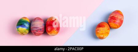 Painted Easter eggs in red yellow and orange on a blue and pink background with a place for text. Happy Easter concept. Greeting card. Banner Stock Photo