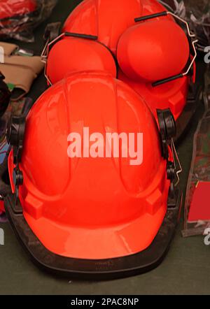 Pile of protective red helmets used in construction and building industry Stock Photo