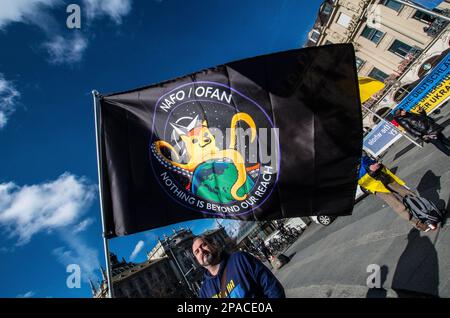 Munich, Bavaria, Germany. 11th Mar, 2023. A flag of NAFO, an anti-propaganda group that combats Russian trolls with memes and facts. As Russia pounds cities across Ukraine with waves of hypersonic missiles, Ukrainians and Germans in Munich, Germany made demands for peace and the immediate withdrawal of Russia from Ukrainian territory. The participants also thanked Germany and the alliance for the support for Ukrainian refugees, humanitarian aid for those in Ukraine, and for the defensive weapons. (Credit Image: © Sachelle Babbar/ZUMA Press Wire) EDITORIAL USAGE ONLY! Not for Commercial USAGE! Stock Photo