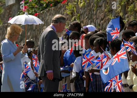 Britain's Prince Charles, center, speaks to school children upon their arrival to Little Bay, in the Caribbean island of Montserrat, Saturday, March 8, 2008, accompanied by his wife Camilla, the Duchess of Cornwall, left. Both toured the area that was devastated by the eruption of the Soufriere Hills volcano a decade ago, as part of a five-island Caribbean tour. (AP Photo/Wayne Fenton)
