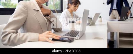 Young caucasian businesswoman using laptop computer and smart phone working at the office, woman and colleagues working with confident at workplace, s Stock Photo
