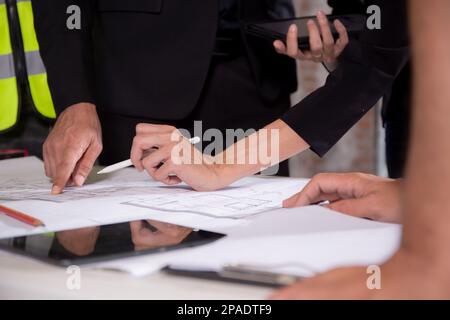 Closeup hands young caucasian architect woman looking laptop and working drawing blueprint for planning building house, engineer thinking and sketchin Stock Photo