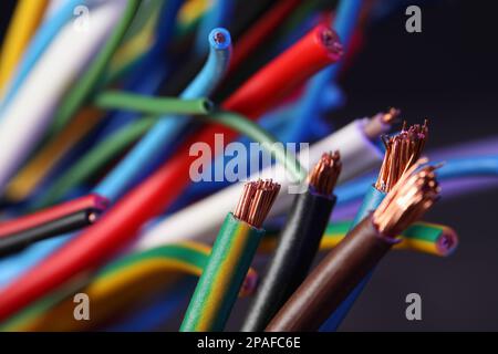 Colorful cables on blurred background, closeup. Electrician's supply Stock Photo