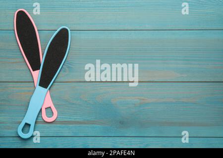 Colorful foot files on light blue wooden table, flat lay with space for text. Pedicure tools Stock Photo