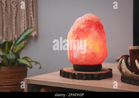 Himalayan salt lamp on wooden table indoors Stock Photo