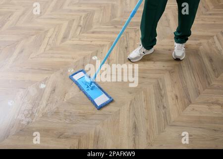 Professional janitor cleaning parquet floor with mop, closeup Stock Photo -  Alamy