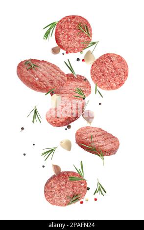 Fresh raw burger patties and seasonings falling on white background Stock Photo