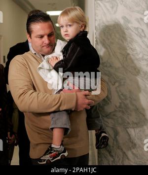 Chuck Knoblauch, former Major Leage Baseball player and former teammate of  Roger Clemens, joined by his wife Stacey, carries his two-year-old son Jake  as he leaves a deposition on drugs in baseball