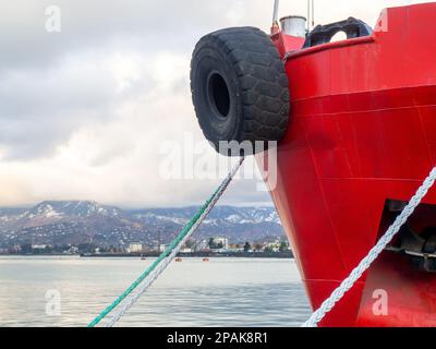 nose of the ship is red. Tire on the bow of the ship. Safety . Moored ship. raised anchor Stock Photo