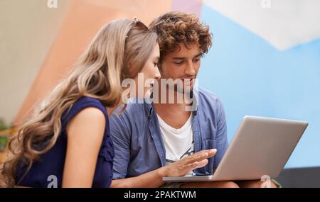 All kinds of chemistry going on...two college students sitting together with a laptop. Stock Photo