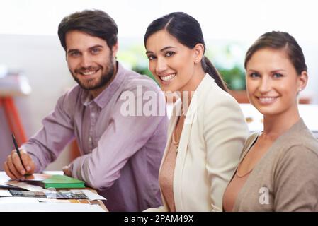 Theyre knowing for always getting the job done. three business associates working together on a project. Stock Photo