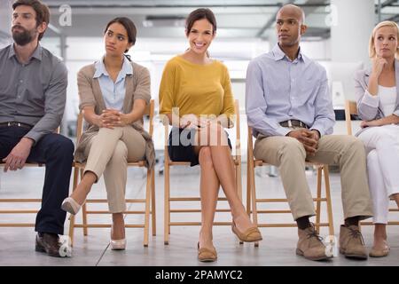 Staying positive in her profession. a group of businesspeople sitting next to each other on a panel. Stock Photo