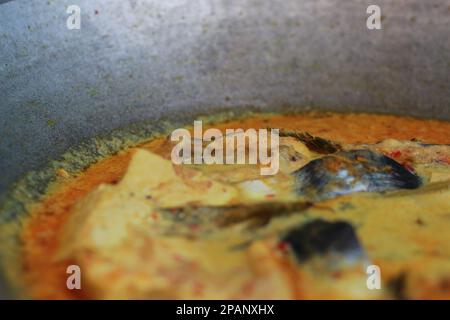 photo of tuna fish and white tofu in yellow spice sauce on a frying pan. Indonesian traditional food photo concept. Stock Photo