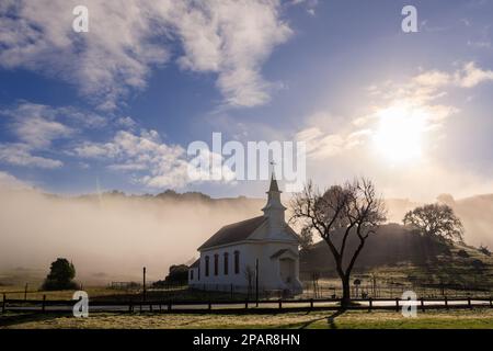 Early morning sun and fog at historic church in rural Marin County, California Stock Photo