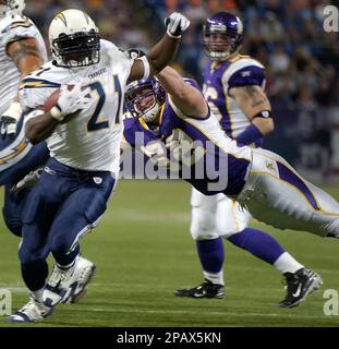 San Diego Chargers' LaDainian Tomlinson (21) is tackled by Tennessee  Titans' Stephen Tulloch, center, and Keith Bulluck, right, on a two-yard  run during the second quarter of their AFC wild-card game Sunday