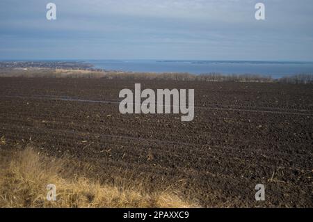 early spring landscape with agricultural field near Dnipro river down to  outskirts of Verkhnodniprovsk city, Ukraine Stock Photo