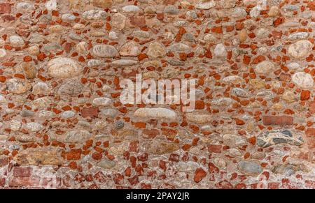 Wall texture with pieces of old red bricks mixed with exposed round river stones. Ideal copy space for banners Stock Photo