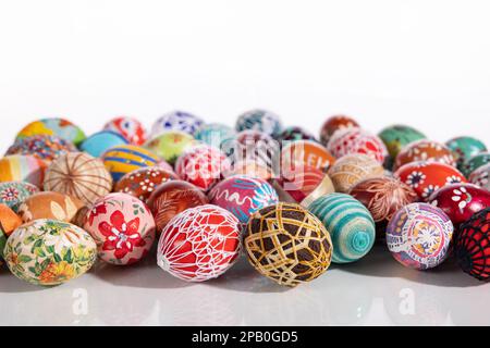 Lots of colorful Easter eggs laid out randomly on a solid white background. Stock Photo