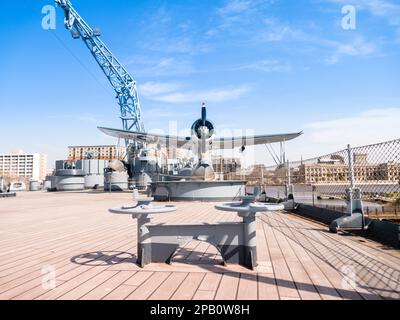 Battleship USS North Carolina docked at Wilmington, NC. Showing head-on view of a Vought OS2U Kingfisher floatplane with catapult on wooden deck. Stock Photo