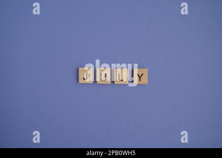 The seventh month of the year July - from isolated letters on wooden blocks in natural color, in high resolution Stock Photo